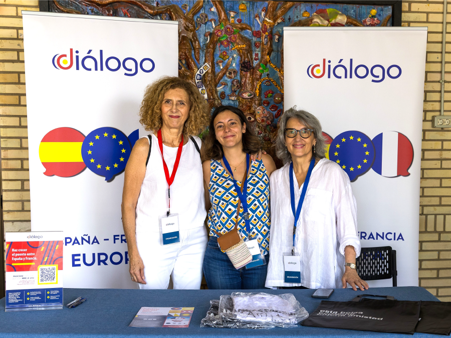 Imagen del stand de Diálogo con 3 personas del equipo mirando a cámara. Stand de Diálogo en La France à Madrid 2025 en el Liceo Francés de Madrid